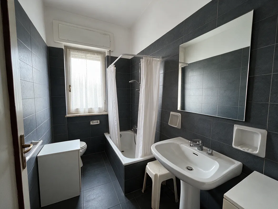 Lo stesso bagno rifatto: gres grafite grande formato, sanitari nuovi