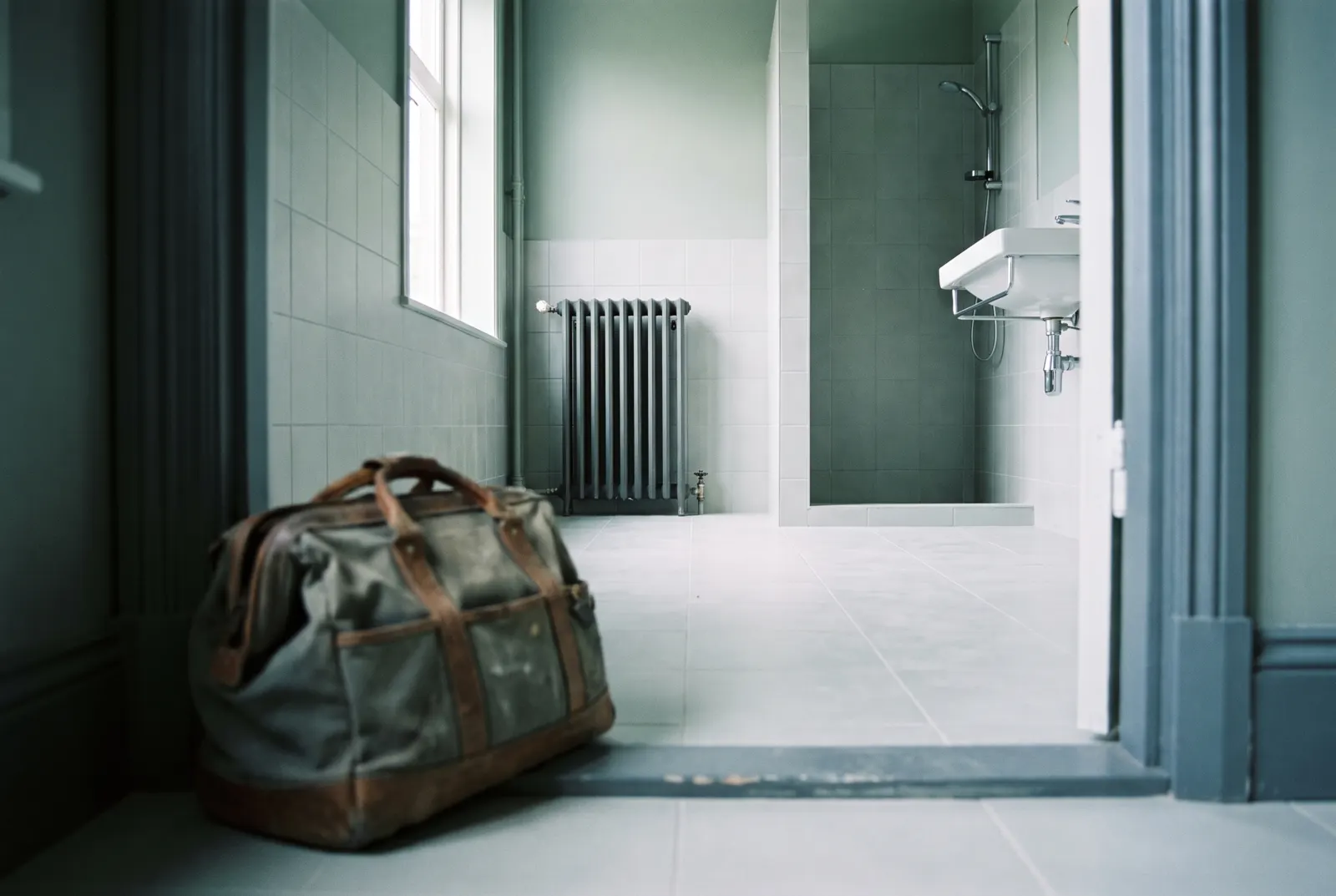 Bagno rifatto e pulito, il borsone degli attrezzi chiuso sulla soglia